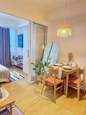 a dining room with a table and a mirror at Maldives Tower Azure in Manila