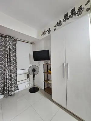 a room with a sliding glass door with a television at The Bahamas & Maldives Suites by Azure Urban Resort Residences in Manila
