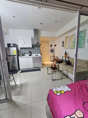 a kitchen and a living room with a couch at The Bahamas & Maldives Suites by Azure Urban Resort Residences in Manila