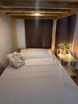 a large white bed in a room with a table at 2 Bedroom and Bathroom Staycation Condo in Mandaluyong City near BONI MRT with WIFI and KARAOKE and POOL in Manila
