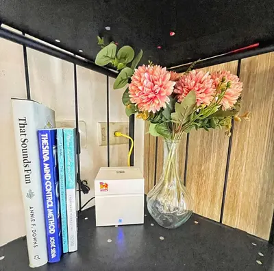 a vase with flowers on a table next to books at Manila Bay, Seaside living near MOA, Studio unit in Manila