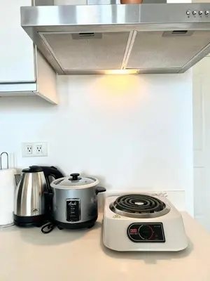 a kitchen counter with a stove and a toaster at Yana's Place - Azure Residences in Manila