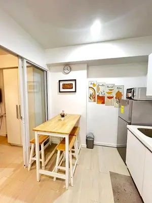 a small kitchen with a wooden table in a room at Yana's Place - Azure Residences in Manila