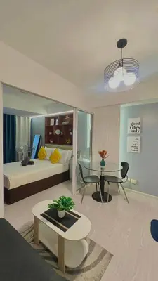 a bedroom with a bed and a desk and a table at Yana's Place - Azure Residences in Manila
