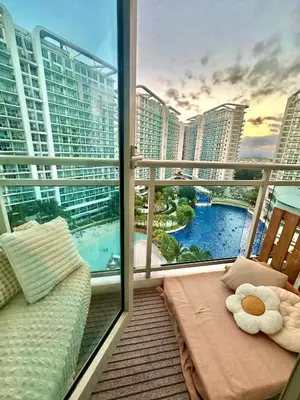 a balcony with a couch and a view of a city at Cozy Stays - Azure in Manila