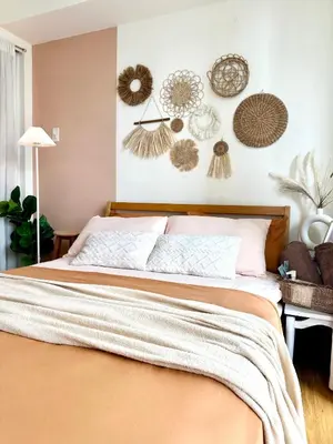 a bedroom with a bed and some decorations on the wall at Cozy Stays - Azure in Manila