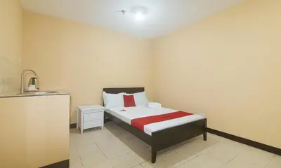 a small bedroom with a bed and a sink at RedDoorz at MUBG Apartelle near Baclaran Church in Manila