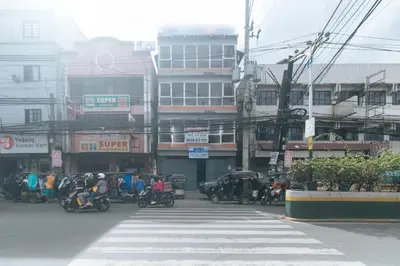 a group of people riding motorcycles on a city street at RedDoorz at MUBG Apartelle near Baclaran Church in Manila