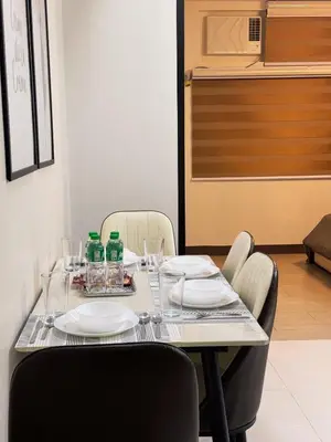 a table with plates and glasses and bottles on it at Sleek & Chic One-Bedroom in Manila
