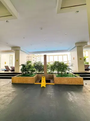 a room with a table with plants and a yellow sign at Sleek & Chic One-Bedroom in Manila