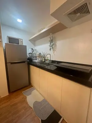 a kitchen with a sink and a refrigerator at EDSA Cozy 3BR near MRT w Netflix and Karaoke Fun in Manila