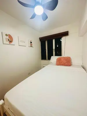 a bedroom with a white bed with a ceiling fan at EDSA Cozy 3BR near MRT w Netflix and Karaoke Fun in Manila