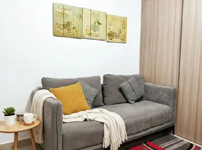 a grey couch in a living room with a table at Mall of Asia - Pasay Condo in Manila