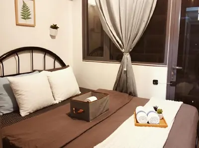 a bedroom with a bed with a tray of towels at MOA Apartment in Pasay in Manila