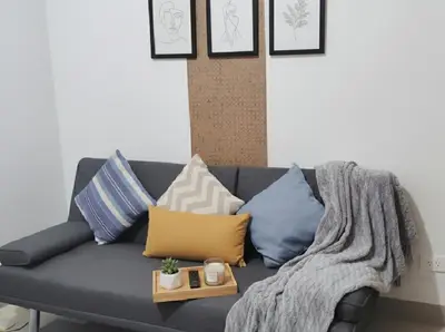 a couch with pillows and a blanket on it at MOA Apartment in Pasay in Manila