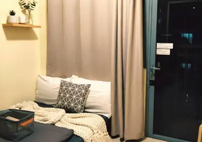 a room with a window and a couch with a pillow at Central Ortigas Condo in Manila