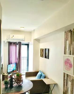 a living room with a couch and a table at SMDC FAME Apartment in Manila
