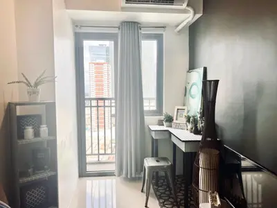 a room with a desk and a large window at SMDC Ortigas FAME in Manila