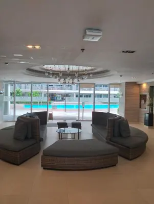 a lobby with couches and a table and a pool at SMDC FAME in Ortigas in Manila