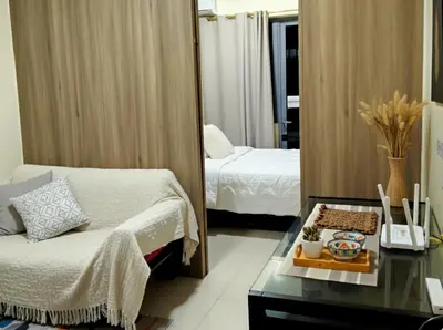 a bedroom with a mirror and a bed and a table at Heart of Ortigas in Manila