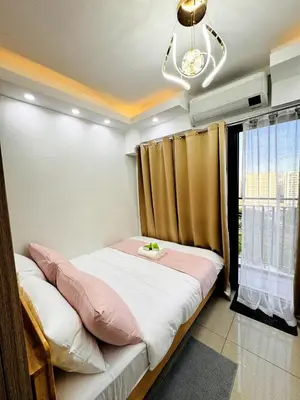 a bedroom with a bed and a window at Lotus' Suite in Manila