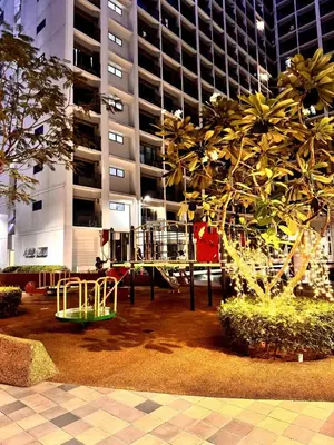 a park with a playground in front of a building at Lotus' Suite in Manila