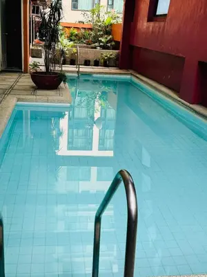 a blue swimming pool with a hand rail in it at Shore Residence a31 shortwalk Mall of Asia in Manila