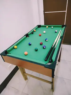 a pool table with balls and cue sticks on it at Aki's Place Binangonan in Binangonan