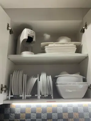 a white refrigerator with plates and utensils in it at Mc Kinley Home Away from Home in Manila