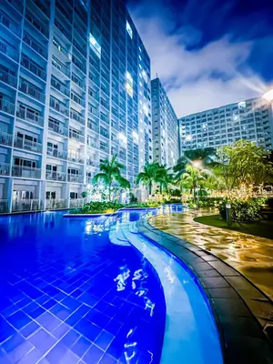 a swimming pool in front of a tall building at Seventh Ave in Manila