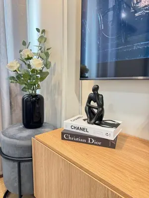 a statue of a woman sitting on top of a book at The Niall's Suites at HOPE Residences besides SM TRECE in Trece Martires