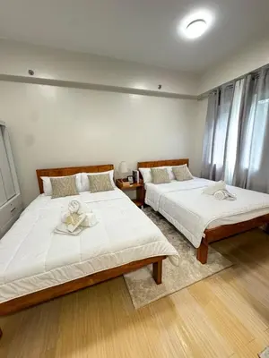 a bedroom with two beds with towels on them at The Niall's Suites at HOPE Residences besides SM TRECE in Trece Martires
