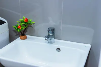 a bathroom sink with a flower on top of it at Witty Weekend retreat Quirk Cozy in Manila