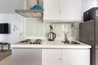 a white kitchen with a sink and a refrigerator at Azure Urban Resort Residences,BORACAY tower model unit in Manila
