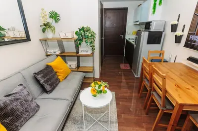 a living room with a couch and a table at Urban Charm Cozy Meet 60 Air Swim Gym Park 300Mb in Manila