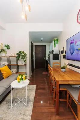a living room with a couch and a table at Urban Charm Cozy Meet 60 Air Swim Gym Park 300Mb in Manila