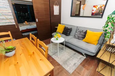 a living room with a couch and a table at Urban Charm Cozy Meet 60 Air Swim Gym Park 300Mb in Manila