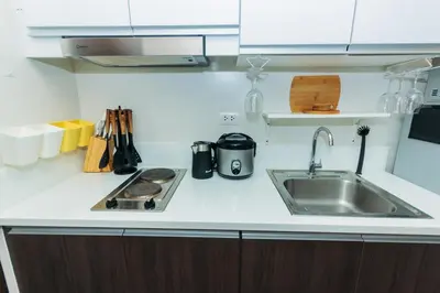 a kitchen counter with a sink and a stove at Urban Charm Cozy Meet 60 Air Swim Gym Park 300Mb in Manila