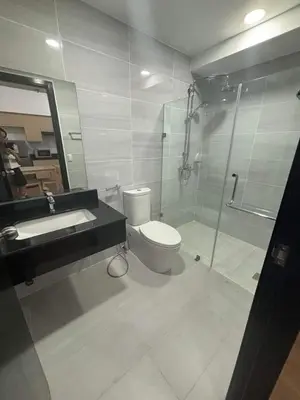 a bathroom with a toilet and a shower and a sink at City Front Studio in Manila