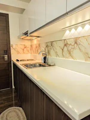 a kitchen with a white counter and a sink at Charming Comfort 1BR at Air Residences Makati with wifi & netflix in Manila