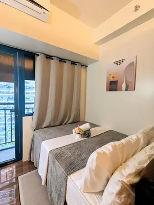 a bedroom with two beds and a window at Charming Comfort 1BR at Air Residences Makati with wifi & netflix in Manila