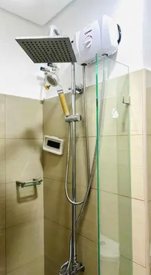 a shower in a bathroom with a blow dryer at Cozy Retreat at Shore2 Residences in Manila
