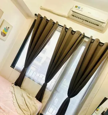 a bedroom with a window with black curtains at Cozy Retreat at Shore2 Residences in Manila