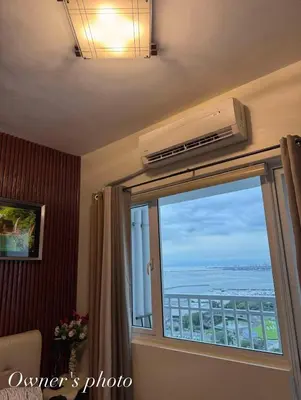 a room with a window with a view of the ocean at JUVREY 1 BR Studio Unit with balcony in Manila