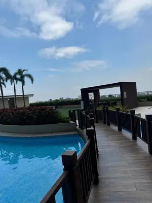 a swimming pool on a resort with palm trees at JUVREY 1 BR Studio Unit with balcony in Manila