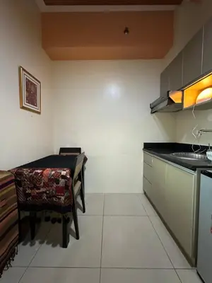a kitchen with a table and a sink in it at Quaint Roces Studio in Manila