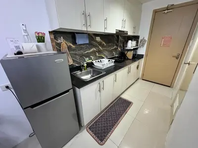 a small kitchen with a sink and a refrigerator at 1bedroom with balcony at Sea Residences near MOA and SMX in Manila