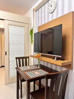 a dining room with a table and a tv at 1bedroom with balcony at Sea Residences near MOA and SMX in Manila