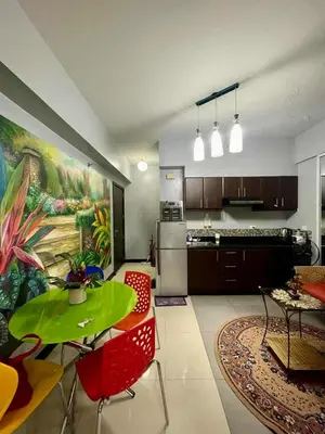 a kitchen with a green table and red chairs at Tropical unit in Manila