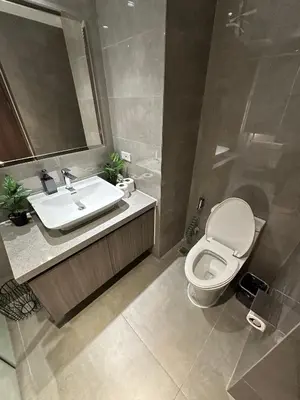 a bathroom with a white toilet and a sink at Spacious 2BR Apartment Hotel near City of Dreams, Airport, MOA, Okada, Ayala Malls, and Solaire Casino with free 5 pool access in Manila